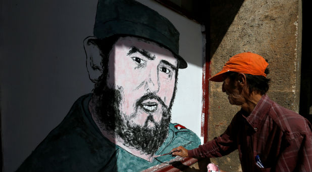 A local artist paints a portrait of Fidel Castro in front of a shop in downtown Havana following the announcement of the death of the Cuban revolutionary leader