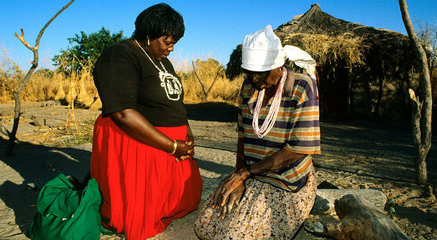 Two women come together in prayer.