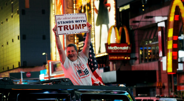 A man leans out of a Hummer shouting words in support of U.S. Republican presidential nominee Donald Trump while driving through Times Square in New York