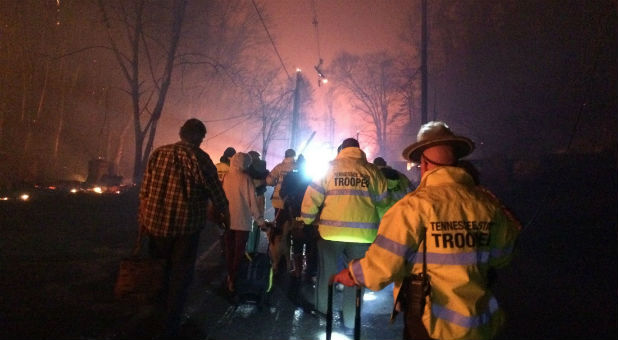 Troopers from the Tennessee Highway Patrol help residents leave an area under threat of wildfire after a mandatory evacuation was ordered in Gatlinburg, Tennessee