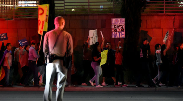 A Las Vegas police officer stands watch as demonstrators march in protest against the election of Republican Donald Trump as president of the United States in Las Vegas.