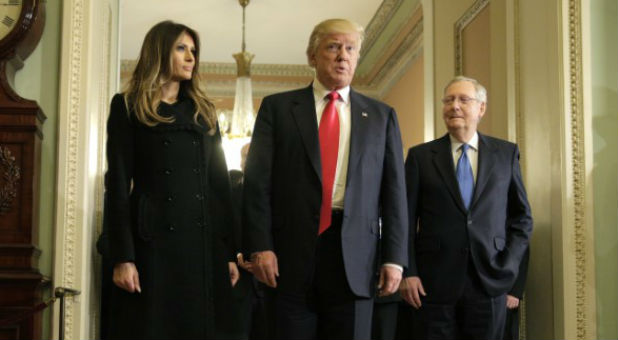 U.S. President-elect Donald Trump (center) answers questions as his wife Melania Trump and Senate Majority Leader Mitch McConnell (R-KY) watch on Capitol Hill in Washington, U.S.