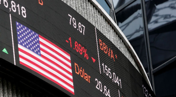 A screen displaying the exchange rate for Mexican peso and U.S. dollars next to the U.S flag is seen at Mexican stock market building in Mexico City, Mexico