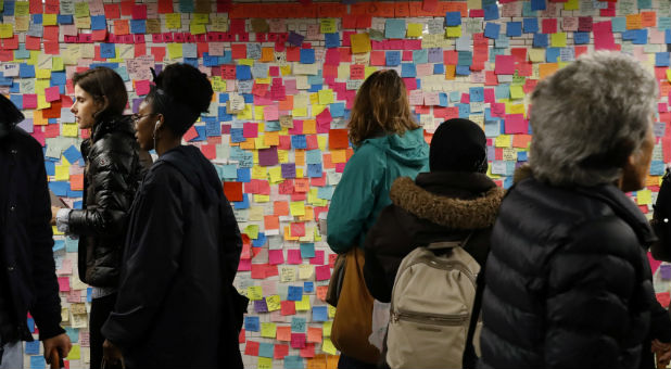 Commuters stop to read and photograph messages written on post-it notes regarding the election of President-elect Donald Trump in New York