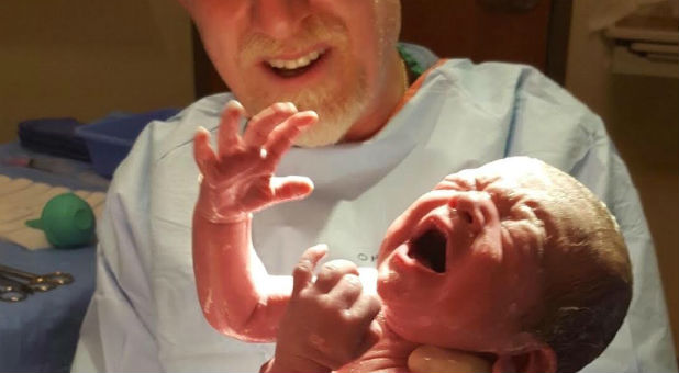 Dr. Brent Boles holds a new baby.