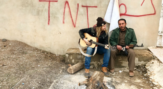 Sean Feucht, left, sings music with a man in a refugee camp.