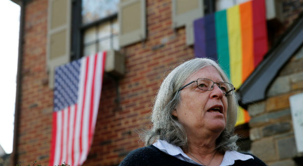 Homeowner Joanna Pratt is interviewed by Reuters in front of her house, which flies the U.S. and rainbow flags in solidarity with the LGBT community in Washington