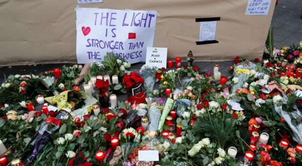 Flowers and posters are placed at the scene where a truck plowed into a crowded Christmas market in the German capital last night in Berlin, Germany