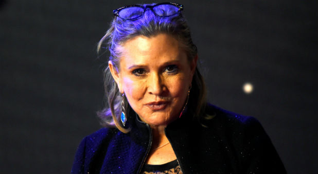 Carrie Fisher poses for cameras as she arrives at the European Premiere of Star Wars, The Force Awakens in Leicester Square, London