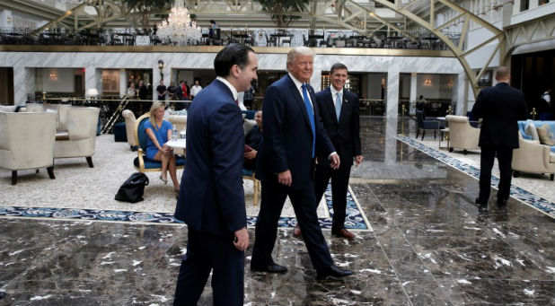 Donald Trump walks through the atrium of his new Trump International Hotel in Washington