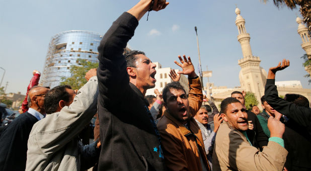 Egyptian Christians react and shout slogans as ambulances transport the bodies of victims killed in the bombing of Cairo's main Coptic cathedral after the funeral, in Cairo, Egypt.