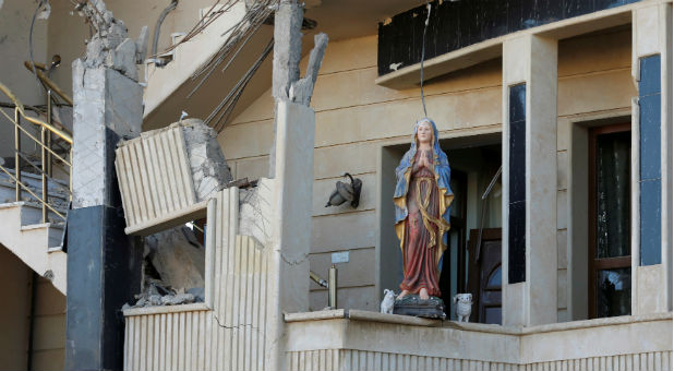 A damaged statue of the Virgin Mary is seen in a church in Qaraqosh, east of Mosul, Iraq