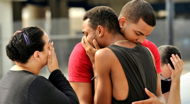 Friends and family members embrace outside the Orlando Police Headquarters during the investigation of a shooting at the Pulse night club, where as many as 20 people have been injured after a gunman opened fire, in Orlando, Florida, June 12, 2016.