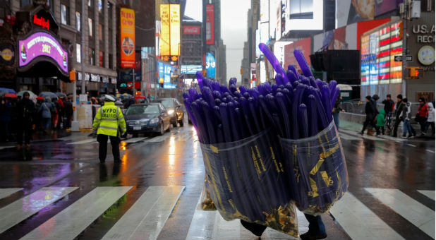 A worker carries balloons to a storage pod ahead of New Year's celebrations in Times Square
