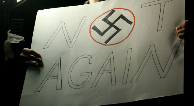 A man holds a sign with a swastika displayed during a protest against U.S. President-elect Donald Trump