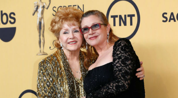 Actress Debbie Reynolds poses with her daughter actress Carrie Fisher backstage after accepting her Lifetime Achievement award at the 21st annual Screen Actors Guild Awards in Los Angeles on Jan. 25, 2015.