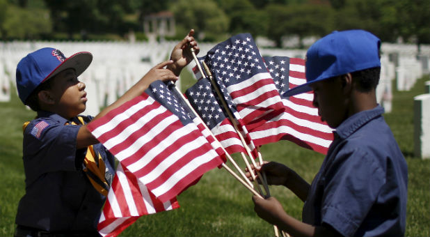 Members of the Boy Scouts of America organize U.S. flags to be placed at graves at Cypress Hills National Cemetery in Brooklyn, New York