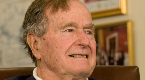 Former President George H.W. Bush smiles as he listens to Republican presidential candidate Mitt Romney speak as he met with Bush to pick up his formal endorsement in Houston in this March 29, 2012 file photo.