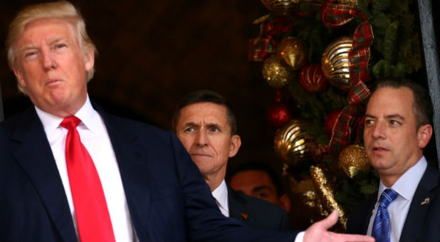 Incoming White House Chief of Staff Reince Priebus (R) and U.S. Army Lieutenant General Michael Flynn (C) look at U.S. President-elect Donald Trump