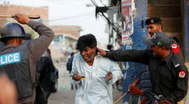 Police beat and detain a Pakistani Christian protester during a demonstration against Saturday's burning of Christian houses and belongings in Badami Bagh, Lahore, March 10, 2013.