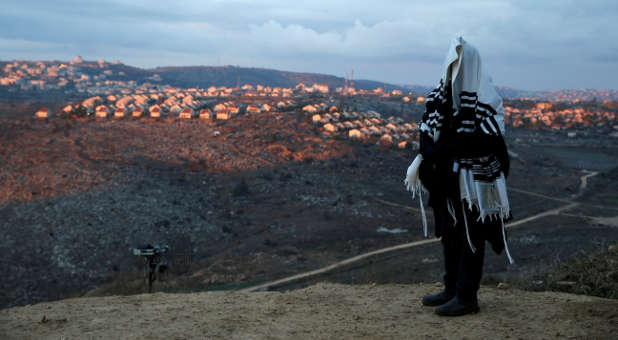 A Jewish man covered in a prayer shawl prays in the Jewish settler outpost of Amona in the West Bank.
