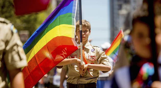 Boy Scout Carrying a Gay Pride Flag