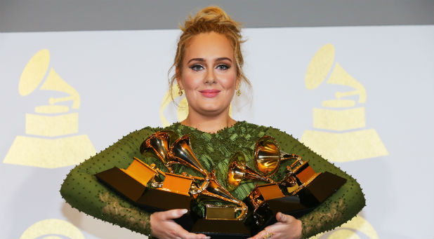 Adele holds up all her Grammys.