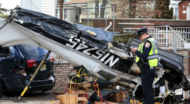 An official surveys the scene where a small plane crash landed on a residential street in Bayonne, New Jersey, Feb. 19, 2017. The pilot survived the crash and was transported to a hospital, according to authorities at the scene.