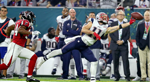 New England Patriots wide receiver Julian Edelman (11) reaches for a pass against Atlanta Falcons cornerback Brian Poole (34) during the fourth quarter during Super Bowl LI at NRG Stadium.