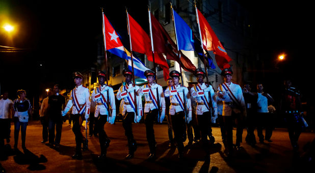 Cuban soldiers carry flags during a march to celebrate the 164th birth anniversary of Cuba's independence hero Jose Marti in Havana, Cuba