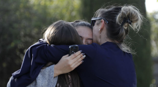 People embrace near the Alexis de Tocqueville high school after a shooting incident injuring at least eight people, in Grasse, southern France.