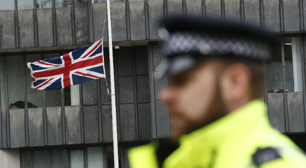 A police officer stands on duty as a Union flag flies at half-mast in Westminster the morning after an attack in London.