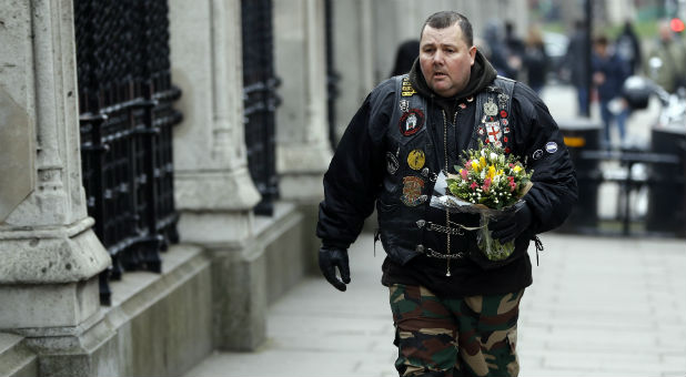 A man carries flowers to a memorial set up for the victims of the London attack.