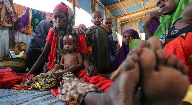 An internally displaced Somali woman sits with her children inside their general shelter at the Al-cadaala camp in Mogadishu.
