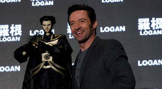 Actor Hugh Jackman poses with a cloth puppet from a traditional type of opera during a news conference during Asian premiere of the X-Men series film 'Logan'