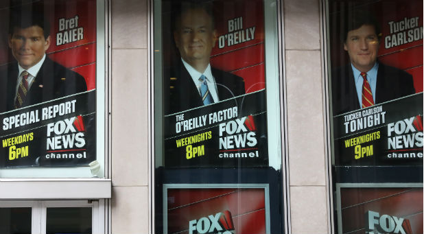 Posters featuring Fox News Channel talent including TV anchor Bill O'Reilly are seen outside the News Corporation headquarters in New York City