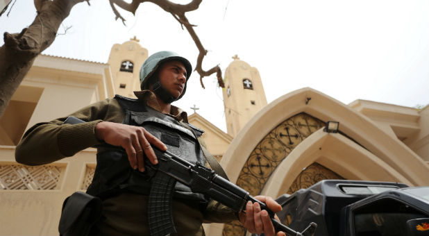 An armed policeman secures the Coptic church that was bombed on Sunday in Tanta, Egypt