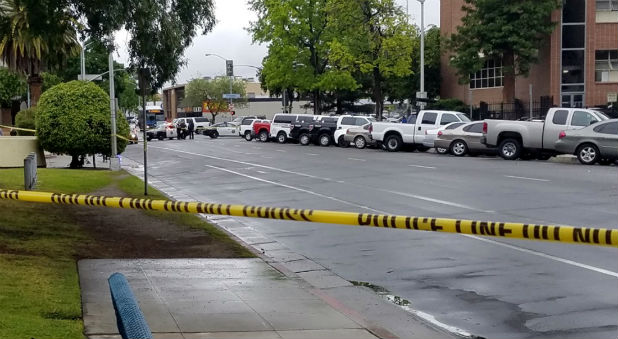 A road is blocked by police tape after a multiple-victim shooting incident in downtown Fresno, California