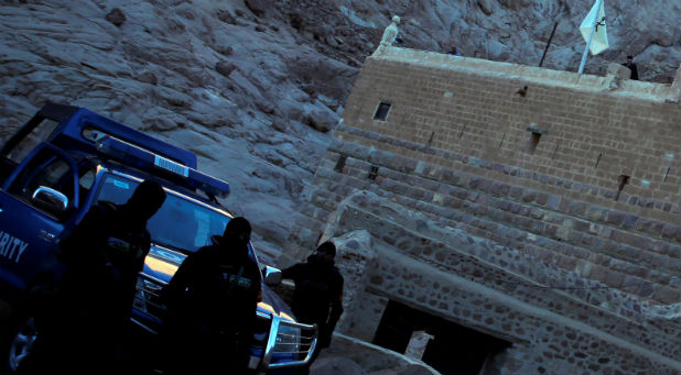 Special police forces stand guard as a Greek monk is seen on the top of a church at Saint Catherine's monastery, in the Sinai Peninsula, south of Egypt, in this file photo taken December 8, 2015.