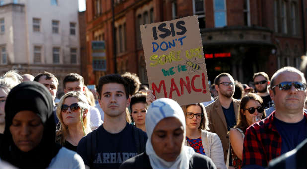 A woman holds a placard as people take part in a vigil for the victims of an attack on concert goers at Manchester Arena, in central Manchester, Britain.