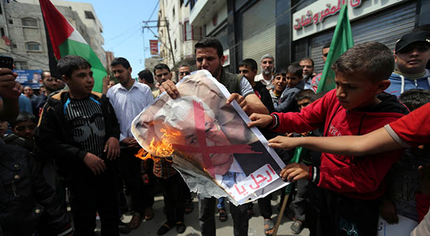 Palestinians in Gaza burning PA President Mahmoud Abbas' photo
