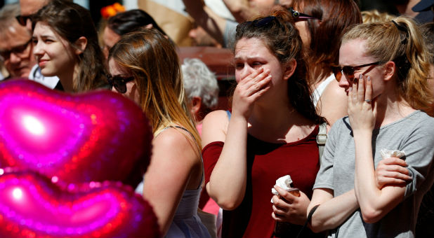 People look at tributes to the victims of the attack on the Manchester Arena, in central Manchester