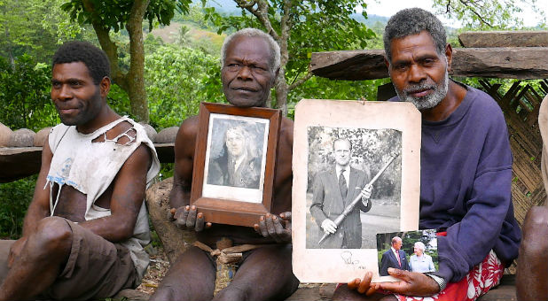Chief Jack Malia (R) from the Imanourane Tribe holds photographs of Britain's Prince Philip as he sits next to other villagers in the village of Younanen on Tanna Island in the Pacific island nation of Vanuatu