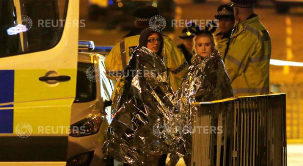 Two women wrapped in thermal blankets stand near the Manchester Arena, where U.S. singer Ariana Grande had been performing, in Manchester, northern England, Britain, on May 23, 2017.