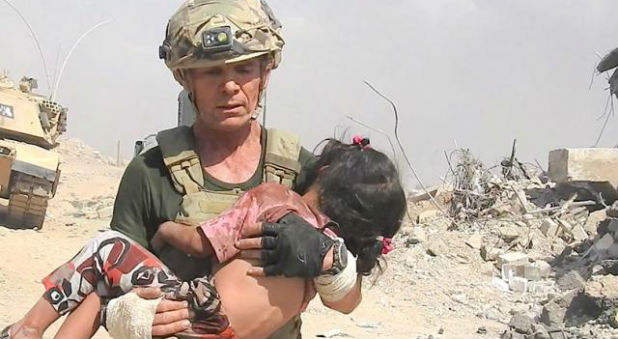 Dave Eubank carrying a little girl to safety with help of U.S. military and Iraqi Army.