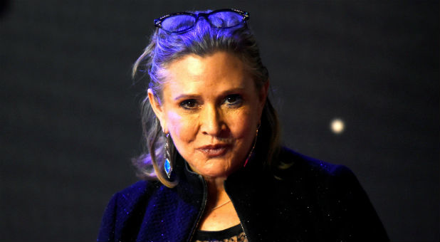 Carrie Fisher poses for cameras as she arrives at the European Premiere of