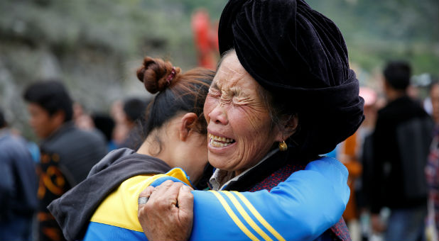 Relatives of victims react at the site of a landslide in the village of Xinmo, Mao County, Sichuan Province.