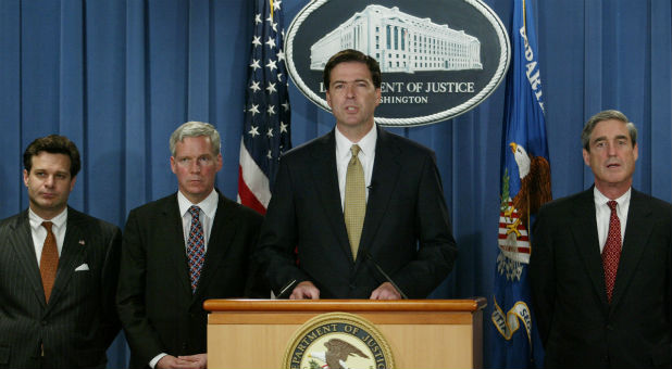 Deputy U.S. Attorney General James B. Comey, accompanied by Assistant Attorney General Christopher A. Wray (L) of the Criminal Division, IRS Commissioner Mark Everson (2nd L) and FBI Director Robert Mueller, speaks during a news conference in the Justice Department in Washington, July 8, 2004.