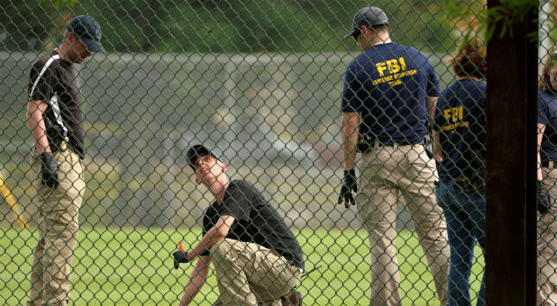 FBI technicians examine the outfield area of a baseball field for evidence where shots were fired during a Congressional baseball practice wounding House Majority Whip Steve Scalise, R-La., in Alexandria, Virginia.