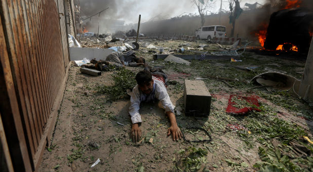 A wounded man lies on the ground at the site of a blast in Kabul.